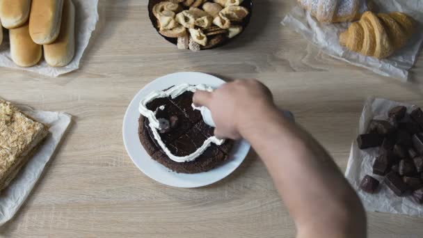 Guy con delizia e appetito decorazione torta con panna montata e ciliegie — Video Stock