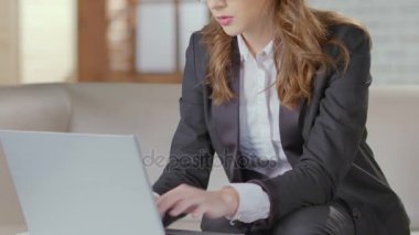 Kanepede oturan ve laptop, Toplantı için hazırlık yazarak işkadını