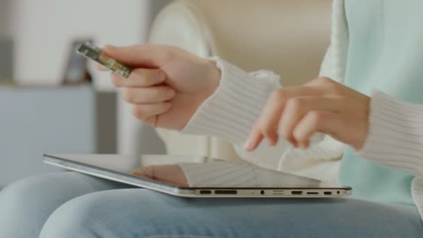 Mão da mulher digitando o número do cartão no tablet, comprando bilhetes online. Close-up — Vídeo de Stock