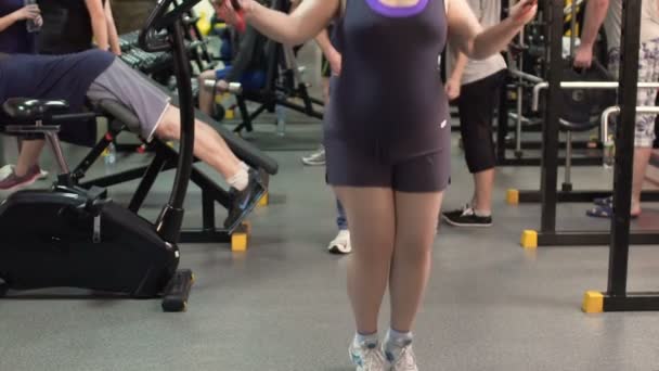 Overweight woman jumping rope in the gym, weight loss and fitness, slow-mo — Stock Video