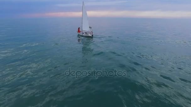 Witte zeilboot met paar op boog omlaag zee richting horizon, toekomstige zwemmen — Stockvideo