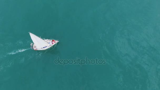 Male female standing at bow of luxurious sailing boat going across turquoise sea — Stock Video