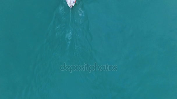 White sailing boat with couple at bow swimming down turquoise ocean, freedom — Stock Video