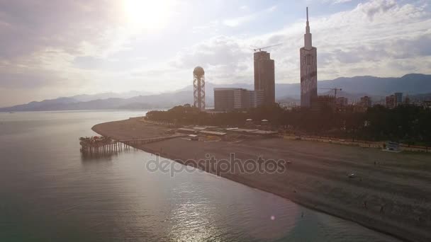 Luz neblina que rodea el paseo marítimo de Batumi con edificios en la parte posterior, al final de la tarde — Vídeos de Stock