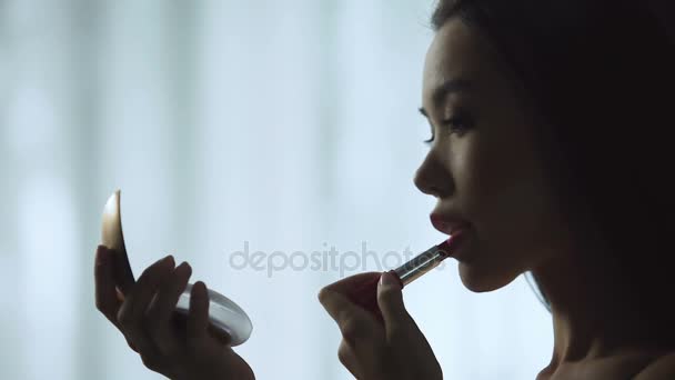 Charmante meisje zorgvuldig zetten rode lippenstift, langzaam schilderen mooie lippen — Stockvideo