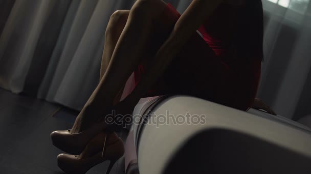 Menina magro em vestido vermelho coloca em saltos altos e vai embora, publicidade sapatos — Vídeo de Stock