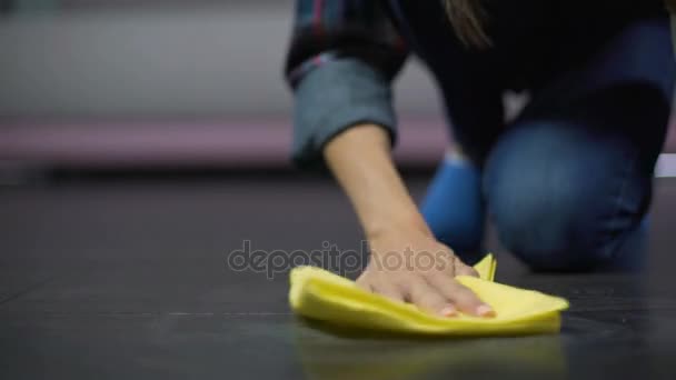 Frustrated woman tries to remove a stain on the floor with cleaning product — Stock Video