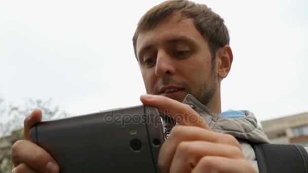 Turista masculino olhando para aplicação com itinerário turístico em seu smartphone — Vídeo de Stock