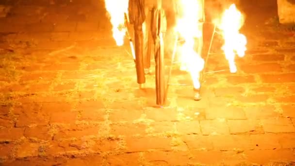 Man performing strange dance on flaming stilts, night street performance culture — Stock Video