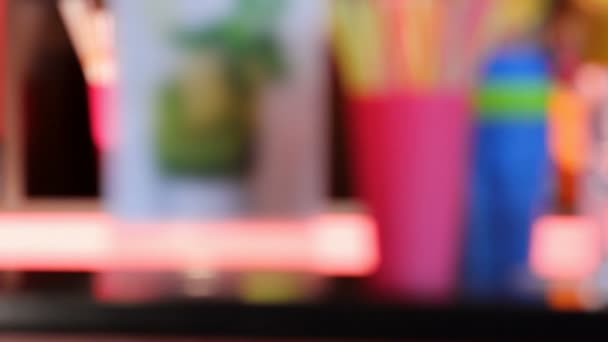 Colorful plastic glasses standing on bar counter, barman pouring juice, party — Stock Video