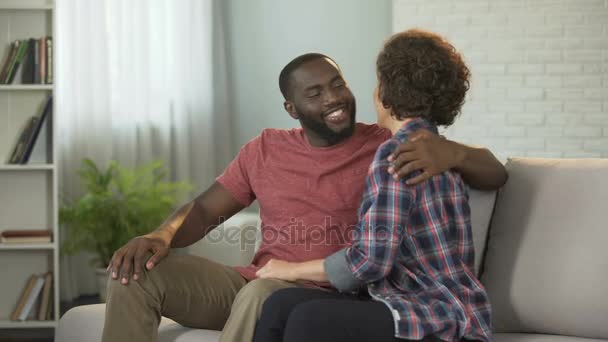 Happy family couple sitting on sofa talking and enjoying pastime with each other — Stock Video