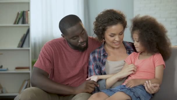 Madre cosquillas y divertir a su hijita, familia sentada en el sofá — Vídeo de stock