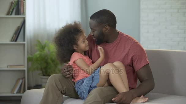 Papá sosteniendo a su pequeña hija en el regazo abrazándola suavemente, paternidad consciente — Vídeo de stock