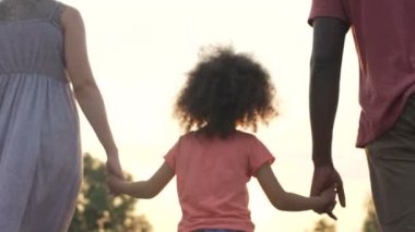 Üç Kişilik bir aile yavaş yavaş gün batımı, mutlu geleceğe birlikte yürüme