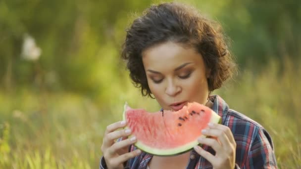 Πανέμορφη γυναίκα τρώει φρέσκο και ζουμερό καρπούζι στην πίσω αυλή, υγιεινή διατροφή — Αρχείο Βίντεο