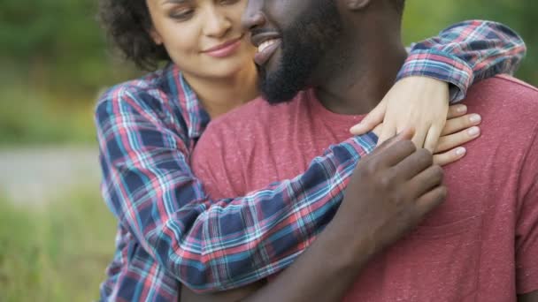 Homem negro e mulher de raça mista carinhosamente abraçando, pessoas felizes sorrindo juntas — Vídeo de Stock