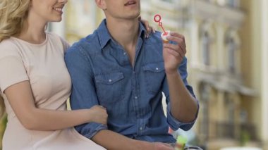 Kaygısız adam oturuyor tezgah ve kabarcıklar üfleme, sevgili, onun tarihi öpüşme üzerinde