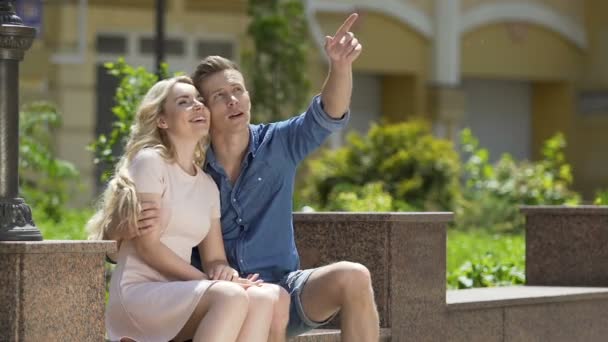 Loving couple of young people sitting on bench and talking, romantic date — Stock Video