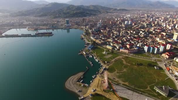 Arquitectura moderna de la ciudad en una orilla del mar con espectaculares montañas, vista al dron — Vídeo de stock
