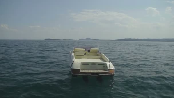 Белая моторная лодка плывет по озеру Гарда в Италии, путешествие, отпуск — стоковое видео