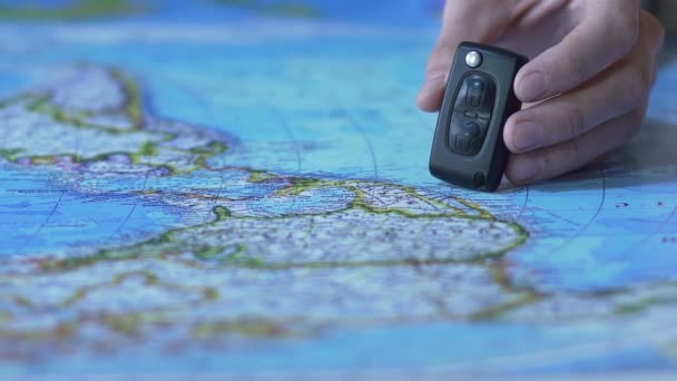 Toy auto si ferma vicino chiave elettronica sulla carta mappa del mondo, trasporto per i viaggi — Video Stock