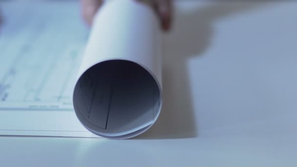 Desenhista abre desenho de layout de edifício em papel, construção de habitação — Vídeo de Stock