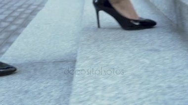 Kadın pahalı yüksek topuk ayakkabı incelikle merdivenlerden yukarı yükselen işkadını