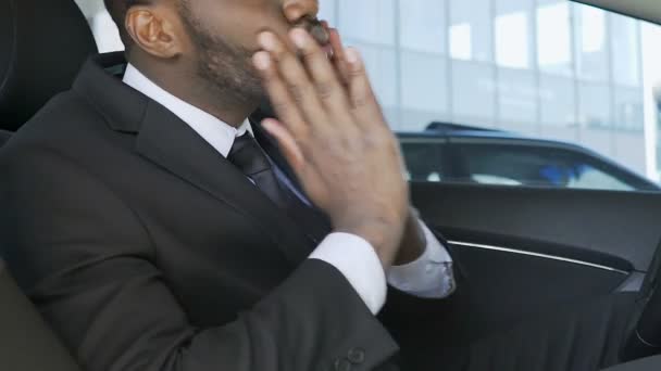 Красивый черный мужчина одевается и регулирует бороду в машине перед собеседованием — стоковое видео