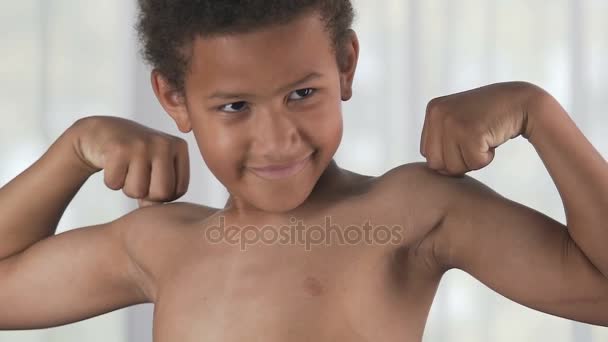 Male kid standing in front mirror with arms flexed, looking at muscles satisfied — Stock Video