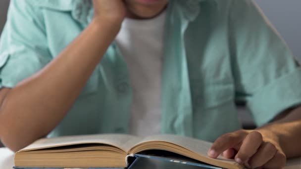 Biracial jongen lezen boek volgende regels met de vinger, home toewijzing, zomer — Stockvideo