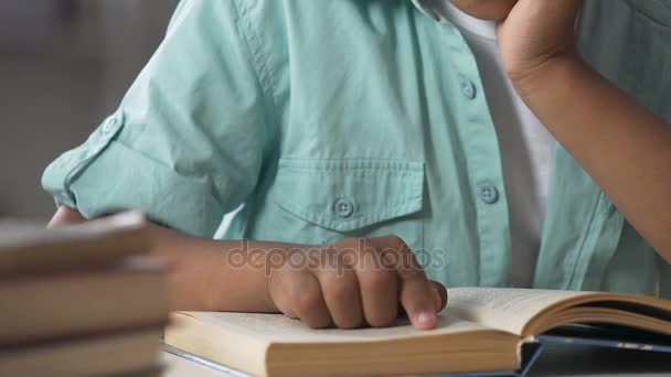 Niño pequeño que tiene dificultades con la lectura del libro, siguiendo líneas con el dedo — Vídeos de Stock