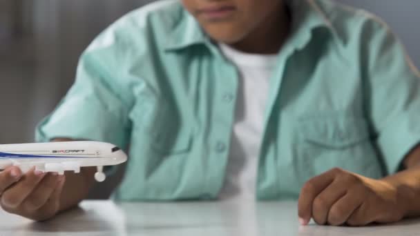 Biracial criança masculina brincando com avião de brinquedo no tempo livre, sonho de infância — Vídeo de Stock