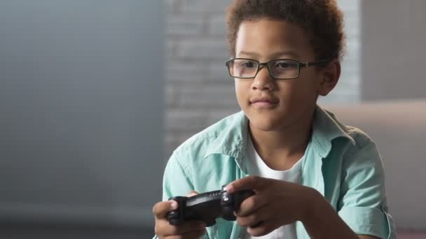 Chico de raza mixta jugando videojuegos, adicción a la estación de juego, hobby inactivo — Vídeo de stock