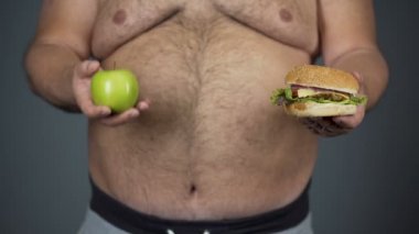 Şişko elma hamburger, yerine seçtiğiniz adam sağlıklı diyet tutmak, closeup karın
