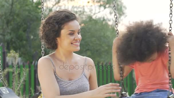 Bonita madre balanceando a su amada hija en el patio trasero, felicidad familiar — Vídeo de stock