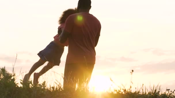 Afrikalı-Amerikalı baba küçük kızı günbatımı parlak ışınları ile oynamak — Stok video