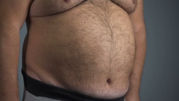 Pessimistic man with beer belly fails to measure waist, unable to fit standards — Stock Video