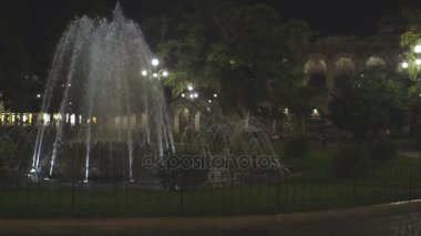 Su jetleri havada park çeşme gece, streetlamps çevresinde çekim aydınlandı