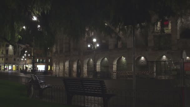 Wand mit nachts beleuchteten Bögen, Lichter von Cafés auf der anderen Straßenseite — Stockvideo