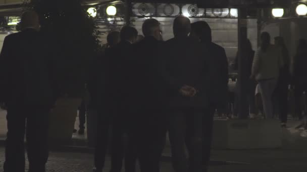 Groupe d'hommes d'affaires en costume marchant dans la rue sombre, vue de dos, ralenti — Video