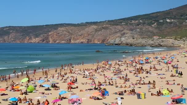 Cascais, Portugalia - Circa Sierpień 2014: Ludzi na plaży. Ludzie, opalając się na zatłoczonej plaży, fale na seashore, słoneczne lato — Wideo stockowe