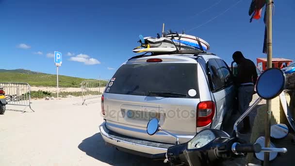 Coche aparcado con tablas de surf atadas a la parte superior, deporte activo durante el verano — Vídeos de Stock