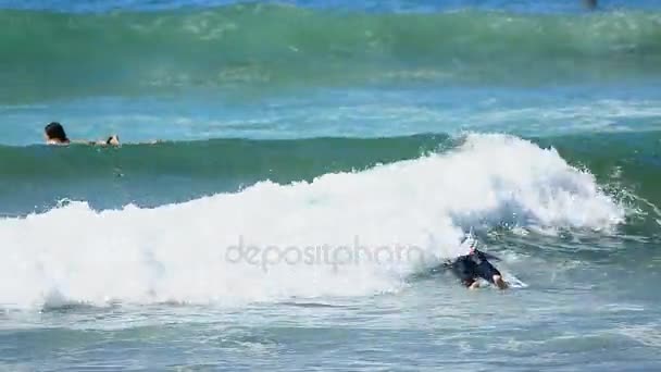 Oceano onda prendendo giovane maschio su tavola da surf di nuovo più vicino alla riva del mare, sport — Video Stock