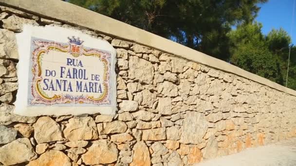 Cartel que muestra el nombre de la calle con los coches estacionados a lo largo de ella, marea baja en el puerto — Vídeo de stock