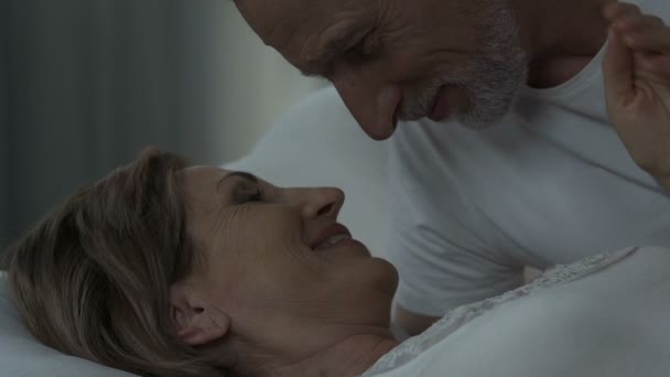 Чоловік з пристрастю дивиться на свою дружину, лежачи в ліжку, здорові сексуальні відносини — стокове відео