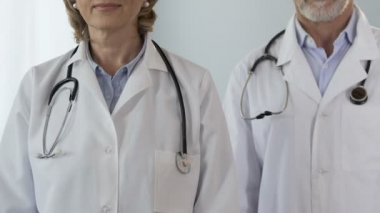 Silah, klinik Hizmetleri katlama kameraya bakarak iki kendine güvenen doktor