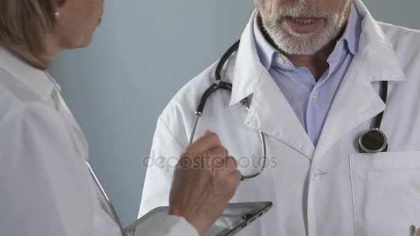 Profesionales argumentando qué método en el tratamiento del paciente aplicar, medicina — Vídeo de stock