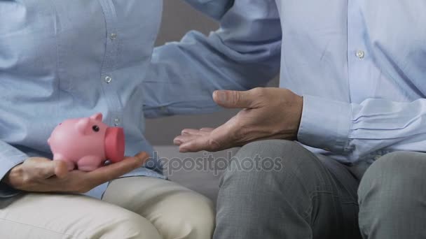 Married couple holding piggy bank in hands, proper family budget planning — Stock Video