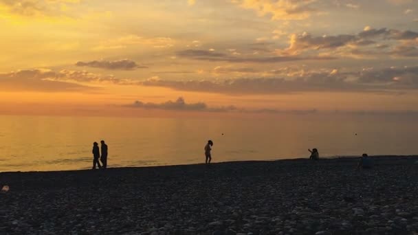 Toeristen silhouetten op het strand op magische uur, zomervakantie aan zee — Stockvideo