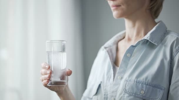 Vrouwelijke pil in glas met water zetten en drinken, de gezondheid van de vrouw — Stockvideo